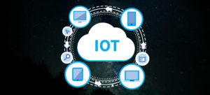 a circle with computer and cellphone icons around it and in the middle a white cloud with the writing "IOT" inside